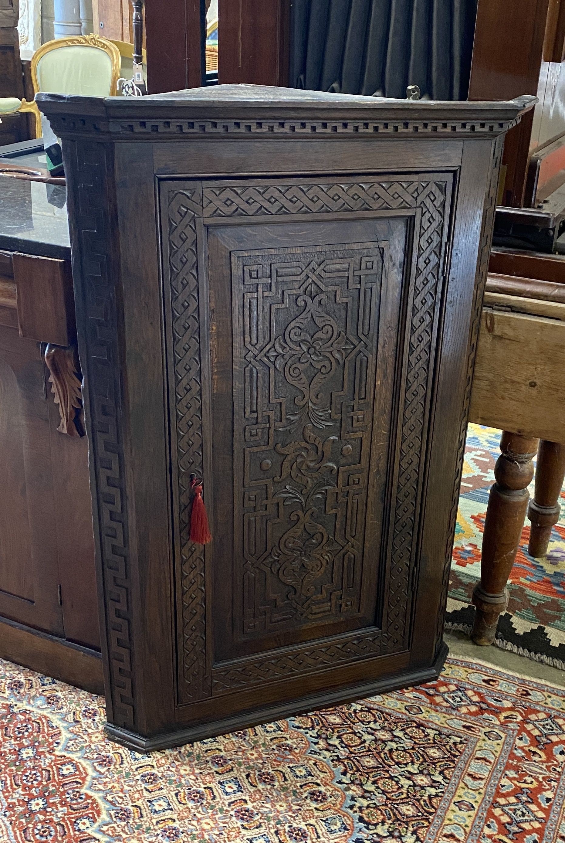 A George III later carved oak hanging corner cabinet, width 72cm, depth 42cm, height 105cm